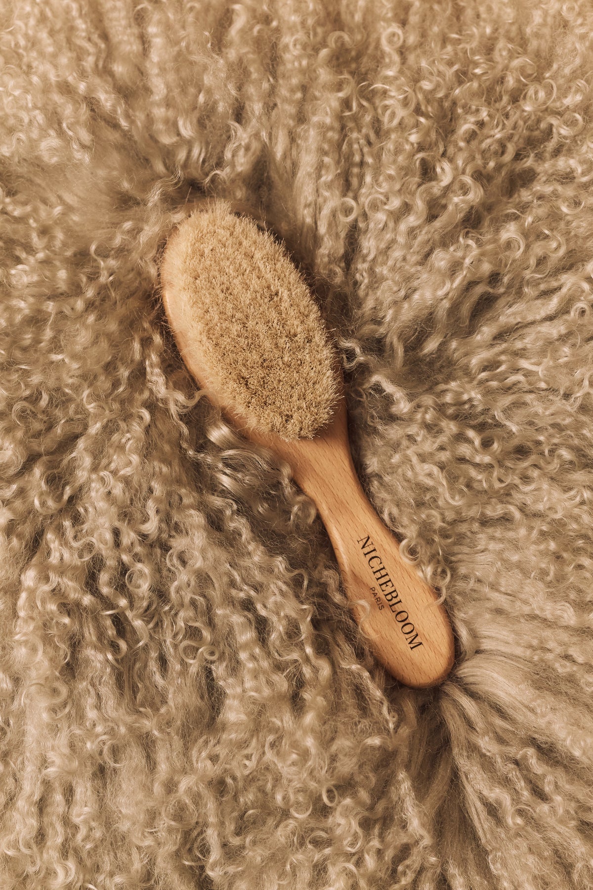 Brosse Nichebloom en bois posée sur une fourrure